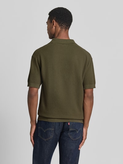 Mannenmodel draagt Regular Fit poloshirt uit puur katoen model 'KOCELLO' van BOSS Orange, effen look, structuurpatroon, labelpatch, polokraag, V-hals, korte mouw, mouwboord en rompzoom geribd, knitwear materiaalverwerking, kleur olijfgroen, achteraanzicht hele lichaam.