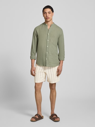 Männermodel trägt Regular Fit Shorts mit Tunnelzug von Jack & Jones aus reiner Baumwolle mit Gesäßtasche, beige mit Streifen, Ganzkörperansicht von vorne.