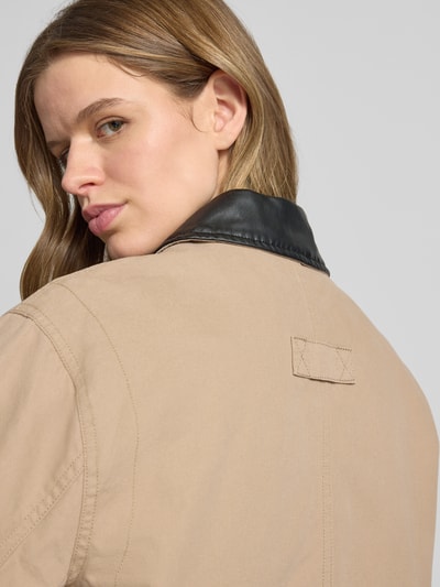 Frauenmodel trägt Jacke mit Brusttasche Modell 'SCOTTY' von Noisy May aus Reine Baumwolle, Relaxed-Fit, Stitching, Detailaufnahme Rückansicht, neutrale Beige- und Schwarztöne.