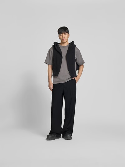 Männermodel trägt Wide Fit Leinenhose mit Gesäßtaschen von WON HUNDRED, schwarzer Farbton, Bügelfalten, Ganzkörperansicht von vorne.