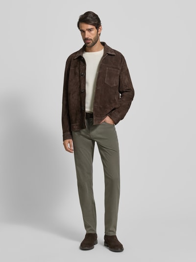 Männermodel trägt Slim Fit Stoffhose mit 5-Pocket-Design Modell 'Cadiz' von Brax aus Baumwoll-Mix mit Stretch-Anteil, Ganzkörperansicht von vorne.