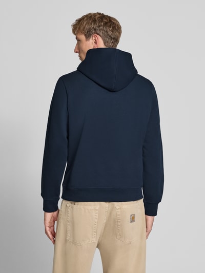 Männermodel trägt dunkelblauen Hoodie mit Label-Print Modell 'FREDERIKSBERG' von JACK & JONES, lockerer Schnitt, Rückenansicht. Baumwoll-Mix, gerippte Abschlüsse, Kängurutasche.
