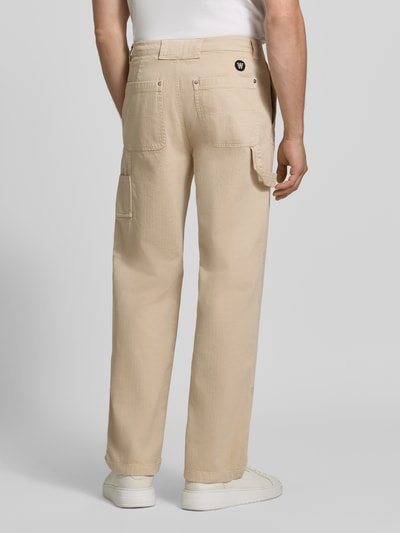 Männermodel trägt Straight Fit Jeans mit Beintaschen von WOOD WOOD in Beige, reine Baumwolle, Gesäßtaschen, Rückansicht, Nahaufnahme Oberkörper.