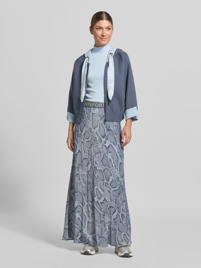 Frauenmodel trägt Slim Fit T-Shirt aus Baumwoll-Mix mit Stehkragen von Marc Cain in Hellblau, kombiniert mit langem Rock in Schlangenoptik; elastischer Baumwoll-Mix, 1/2-Arm, Rückenlänge bei Größe 36: 54 cm, Ganzkörperansicht von vorne