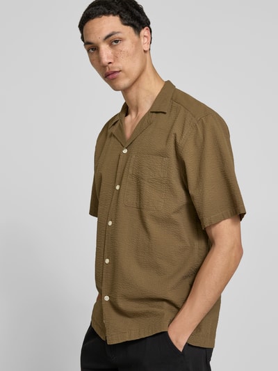 Männermodel trägt Freizeithemd mit Strukturmuster von Forét in Braun, Reine Baumwolle, Regular-Fit, Reverskragen, Kurzärmelig, Ganzkörperansicht von vorne.