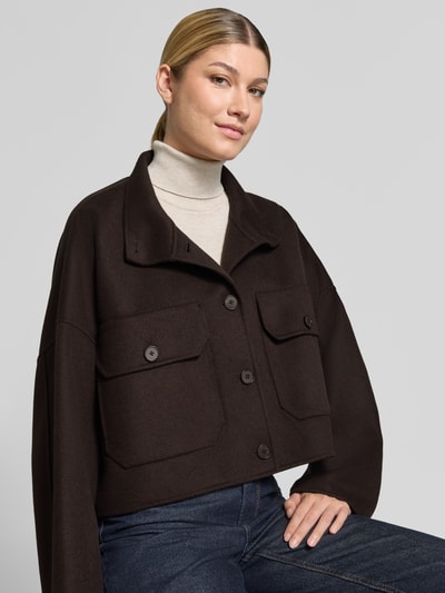 Frauenmodel trägt Boxy Fit Jacke mit Stehkragen Modell 'ARKLOW' von DRYKORN aus Baumwoll-Mix in Dunkelbraun, Nahaufnahme Oberkörper.