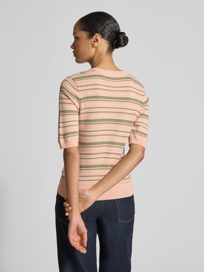 Frauenmodel trägt Strickpullover aus Baumwoll-Mix von Scotch & Soda in Rosa und Grün, taillierte Passform, Rückansicht, Ganzkörperansicht.