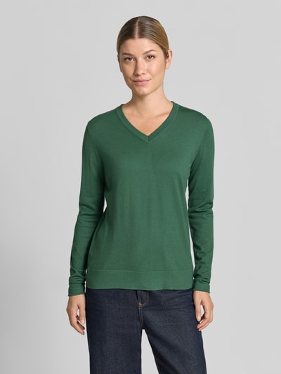 Frauenmodel trägt Pullover aus Viskose-Mix mit V-Ausschnitt von Christian Berg Woman in Dunkelgrün, gerader Schnitt, gerippte Abschlüsse, Ganzkörperansicht von vorne. Rückenlänge bei Größe S 46 cm, Ärmellänge 63 cm.