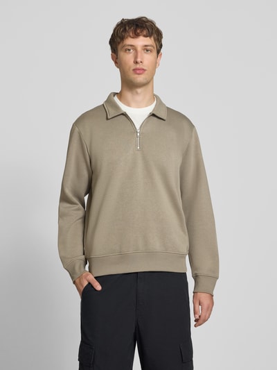 Männermodel trägt Regular Fit Sweatshirt mit Baumwoll-Anteil Modell 'Bradley' von JACK & JONES in Beige, Troyer-Kragen, Ganzkörperansicht von vorne. Material-Mix, Reißverschluss, Rückenlänge bei Größe M 69 cm.