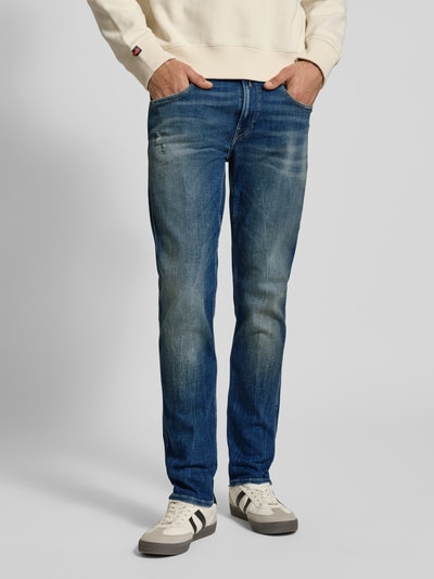 Männermodel trägt Slim Fit Jeans aus Baumwoll-Mix im Destroyed-Look von Replay, blaue Farbe, Kontrastnähte, 5-Pocket-Design, Ganzkörperansicht von vorne.