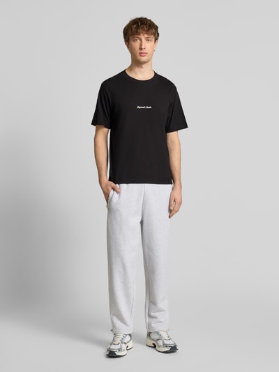 Männermodel trägt schwarzes T-Shirt mit Label-Stitching Modell 'NORREBRO' von Jack & Jones, reine Baumwolle, Ganzkörperansicht von vorne.