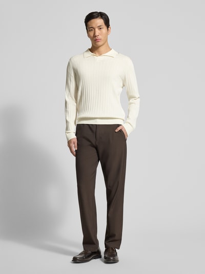 Męski model nosi Loose Fit Poloshirt aus reiner Baumwolle Modell 'TORINO' od SELECTED HOMME, kremowy, długie rękawy, krój loose fit, widok całej sylwetki z przodu.