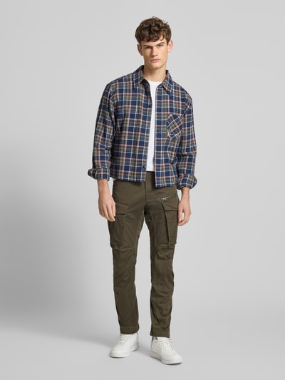 Mężczyzna nosi Regular Tapered Fit Cargohose mit Reißverschlusstasche od G-Star RAW, bawełna z elastanem, oliwkowy kolor, pełny przód.