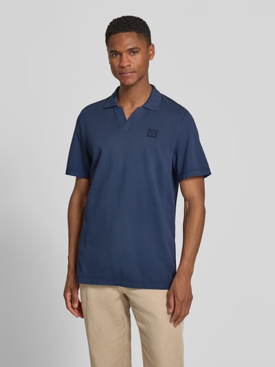 Männermodel trägt Regular Fit Poloshirt aus reiner Baumwolle von s.Oliver RED LABEL, unifarben navy, Piqué-Struktur, Ganzkörperansicht von vorne.