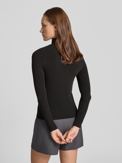 Frauenmodel trägt Regular Fit Langarmshirt mit Viskose-Anteil Modell 'GLAMOUR' von ONLY, schwarz, kombiniert mit grauem Rock, Ganzkörperansicht Rückansicht, Damen Langarmshirt von ONLY.