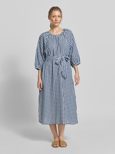 Modelka kobieca nosi Regular Fit Freizeitkleid aus reiner Baumwolle od s.Oliver RED LABEL, niebiesko-biały wzór w kratkę, długość midi, okrągły dekolt, pasek do wiązania, rękaw 3/4, prosty dół, tkanina crinkle, 100% bawełna, widok całościowy z przodu.