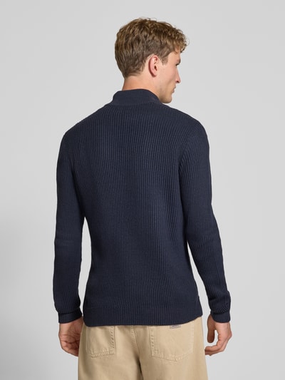 Mężczyznamodel nosi sweter z dzianiny z mieszanki bawełny, kołnierz zapinany, dopasowany krój, Model 'PANNEL' od JACK & JONES, Długość tyłu w rozmiarze M: 70 cm, Długość rękawów w rozmiarze M: 74 cm, widok całej sylwetki od tyłu.