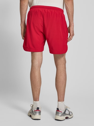 Männermodel trägt Badehose mit Label-Stitching und elastischem Bund von PROHIBITED in Rot, Regular-Fit, Ganzkörperansicht Rückansicht.