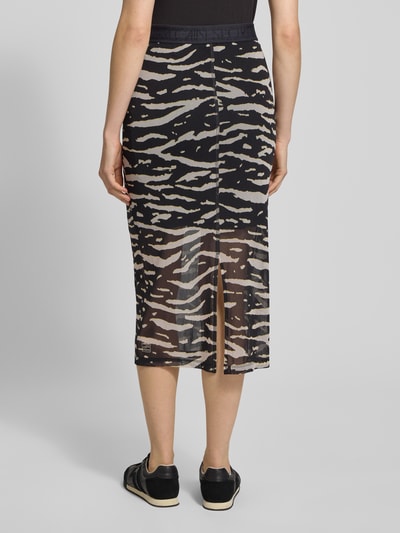 Frauenmodel trägt Midirock mit Gehschlitz und elastischem Bund von Marc Cain, Gerader-Schnitt, Allover-Look, semitransparent, Rückansicht.