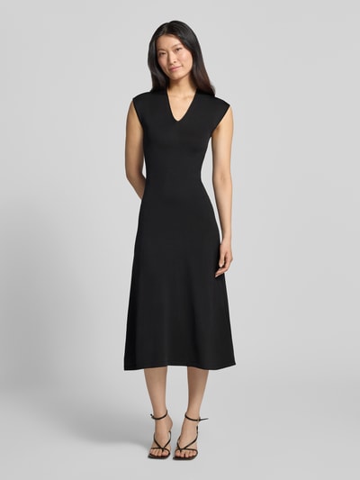 Frauenmodel trägt Kleid aus Viskose-Mix Modell 'CANELONS' von MANGO in Schwarz, taillierte Passform, ärmellos, Midilänge, Ganzkörperansicht von vorne.