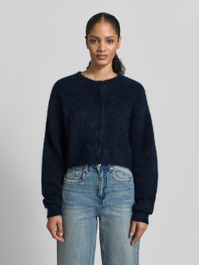 Frauenmodel trägt Cropped Strickjacke mit Knopfleiste Modell 'debbie' von Gestuz im Woll-Mohair-Mix mit Stretch-Anteil, lockerer Schnitt, gerippte Abschlüsse, Rundhalsausschnitt, Dunkelblau, Ganzkörperansicht von vorne.