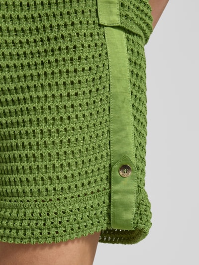 Frauenmodel trägt Bermudas mit fixiertem Saumaufschlag von Marc Cain in Grün, Baumwoll-Mix mit Viskose, Detailaufnahme seitlich.