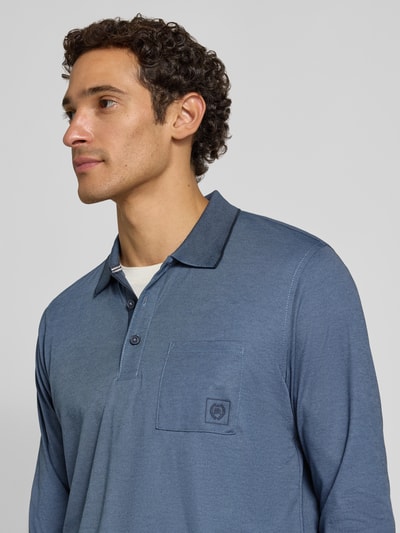 Männermodel trägt Regular Fit Poloshirt in Two-Tone-Machart von LERROS, Baumwoll-Mix, Brusttasche, Logo, Knopfleiste, Longsleeve, Nahaufnahme Oberkörper.