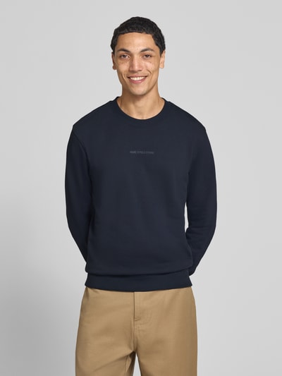 Männermodel trägt Regular Fit Sweatshirt aus reiner Baumwolle von Marc O'Polo DENIM, dunkelblau, glatte Textur, Ganzkörperansicht von vorne.