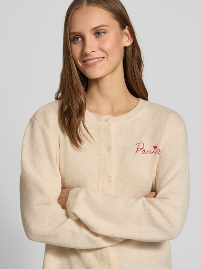 Frauenmodel trägt Regular Fit Strickjacke mit Rundhalsausschnitt Modell 'EVIA' von ONLY, cremefarben, flauschige Textur, Nahaufnahme Oberkörper, Damen Strickjacke von ONLY