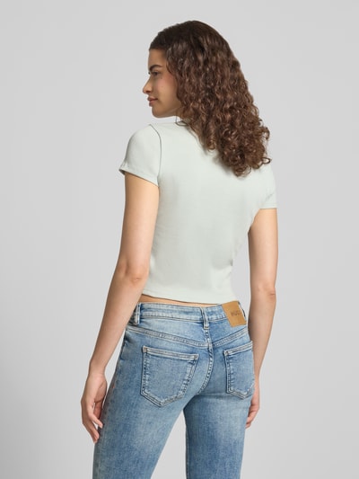 Frauenmodel trägt Slim Fit cropped T-Shirt aus Baumwoll-Mix Modell 'BABY TEE_B' von HUGO in Hellgrau, Damen T-Shirt, Ganzkörperansicht Rückansicht.