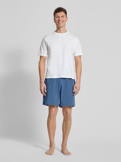 Männermodel trägt Regular Fit Sweatshorts aus Baumwoll-Mix von Tommy Hilfiger in Blau, unifarben, mit Logo-Detail, Ganzkörperansicht von vorne.