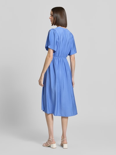 Frauenmodel trägt Midikleid aus Viskose-Mix mit V-Ausschnitt Modell 'Aniva' von ICHI in Blau, Tailliert, Kurzärmelig, Knopfleiste, Ganzkörperansicht Rückansicht. Rückenlänge bei Größe 36: 116 cm, Brustweite: 34 cm, Ärmellänge: 26 cm.