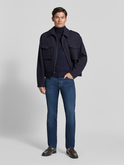 Mężczyznamodel nosi Regular Fit Jeans im 5-Pocket-Design von bugatti, Mieszanka bawełny, zapięcie na guzik i zamek błyskawiczny, 5 kieszeni, Szerokość w rozmiarze 32/32: 43 cm, Długość wewnętrzna nogawki w rozmiarze 32/32: 82 cm, jeansy w kolorze niebieskim. Ganzkörperansicht von vorne.