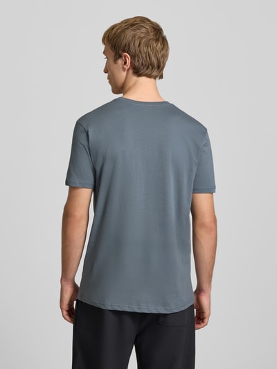 Mannenmodel draagt T-Shirt met Logo en Rundhalsausschnitt van Alpha Industries in grijs, regular fit, zuiver katoen, ruglengte maat M 67 cm, geheellichaamsaanzicht achteraan.