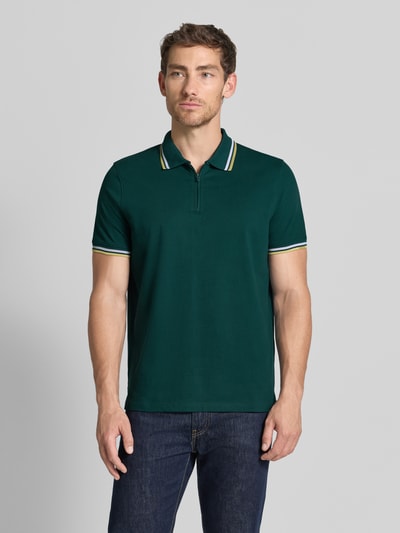 Männermodel trägt Slim Fit Poloshirt mit Kontraststreifen und Reißverschluss von MCNEAL in Dunkelgrün, Baumwollemix, Ganzkörperansicht von vorne.