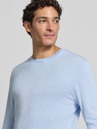 Männermodel trägt Strickpullover mit geripptem Rundhalsausschnitt von MCNEAL in Hellblau, feinmaschig, Nahaufnahme Oberkörper, taillierte Passform.