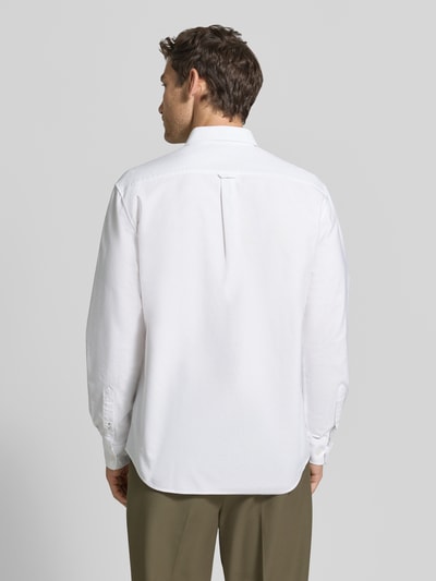 Männermodel trägt Regular Fit Freizeithemd aus reiner Baumwolle von Lacoste in Weiß, glatte Textur, locker geschnitten, Ganzkörperansicht Rückansicht.