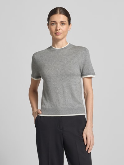 Modelka nosi Strickshirt aus Leinen-Mix in Two-Tone-Machart von Stefanel, damskie, mieszanka lnu z domieszką kaszmiru, krój slim fit, dwa kolory, okrągły dekolt, długość tyłu w rozmiarze S: 54 cm, długość rękawów w rozmiarze S: 20 cm, widok całej sylwetki z przodu.