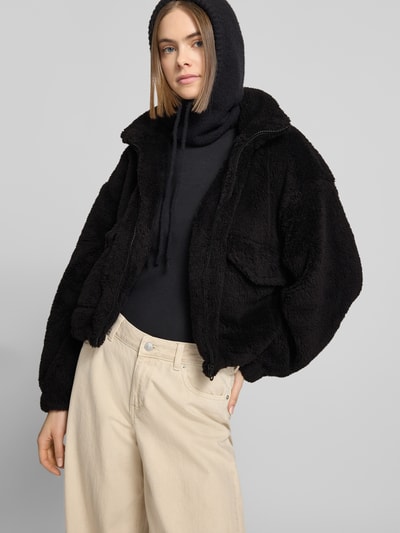 Frauenmodel trägt Loose Fit Fleecejacke mit Stehkragen Modell 'ANNA CONTACT' von Only in Schwarz, unifarben, Kunstwebfell, Ganzkörperansicht von vorne.