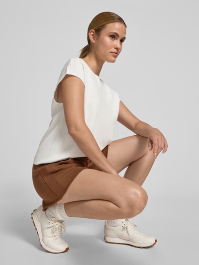 Kobiece model nosi damski t-shirt z mieszanki wiskozy z dodatkiem streczu, krój regular fit, model 'Uvalerie' od Someday, okrągły dekolt, krótkie rękawy, długość tyłu w rozmiarze 36: 57 cm, jasny odcień, gładka faktura, widok z przodu całej sylwetki.
