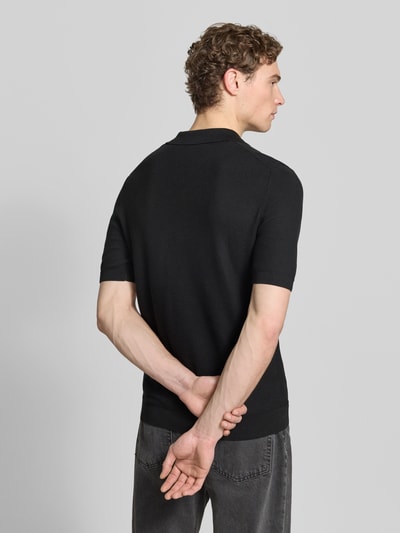 Männermodel trägt Slim Fit Poloshirt mit Viskose-Anteil von Roy Robson, schwarze Strick-Optik, Strukturmuster, Ganzkörperansicht Rückansicht.