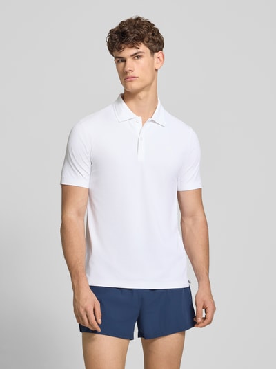 Männermodel trägt Slim Fit Poloshirt mit Logo Modell 'EDMOND' von Ellesse aus Material-Mix mit Stretch-Anteil, Ganzkörperansicht von vorne.