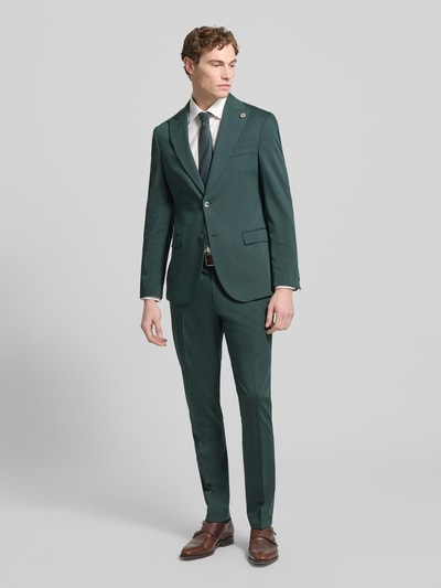 Männermodel trägt Regular Fit Stoffhose aus Satin von MCNEAL in Dunkelgrün, mit Bügelfalten, Gesäßtaschen, Eingrifftaschen, Haken- und Reißverschluss, Ganzkörperansicht von vorne.