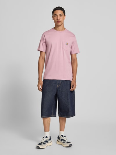 Männermodel trägt Regular Fit T-Shirt mit Brusttasche von Carhartt Work In Progress aus Reine Baumwolle, Ganzkörperansicht von vorne.