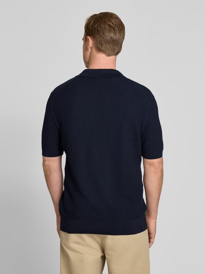 Męski model nosi Regular Fit Poloshirt aus reiner Baumwolle Modell 'NATALO' von BOSS, granatowy, faktura pikée, krój regular fit, widok całej sylwetki od tyłu.
