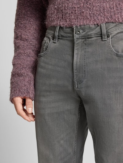 Männermodel trägt Bequeme Slim Fit Jeans in grauer Waschung und Five-Pocket-Design von REVIEW, Nahaufnahme Oberkörper, Baumwoll-Mix mit Stretch-Anteil.