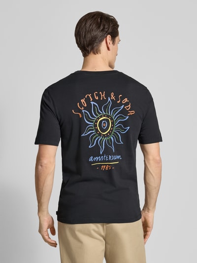 Männermodel trägt T-Shirt mit Label-Prints und Rundhalsausschnitt von Scotch & Soda, Reine Baumwolle, Regular-Fit, Rückenlänge 67 cm, Ganzkörperansicht Rückansicht.