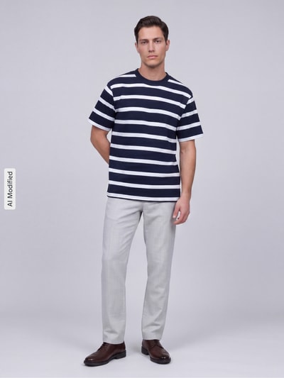 Männermodel trägt T-Shirt mit geripptem Rundhalsausschnitt von MCNEAL, Regular Fit, dunkelblau-weiß gestreift, Ganzkörperansicht von vorne.