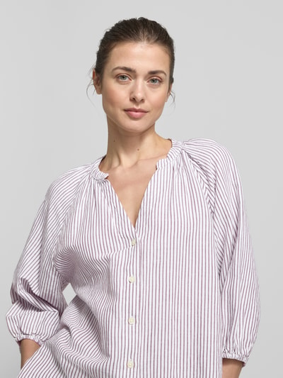 Kobiece modelka nosi bluzkę koszulową Relaxed Fit Hemdbluse Leinen-Baumwoll-Mix model 'ALBERTA' od Selected Femme, efekt: wzór w paski, mieszanka lnu i bawełny, listwa guzikowa, dekolt w serek, rękaw o dł. 3/4, raglanowe rękawy, elastyczne zakończenia rękawów, zaokrąglone wykończenie, kolor wielokolorowy, jednokolorowy, wzór w paski, widok na górną część ciała z przodu.