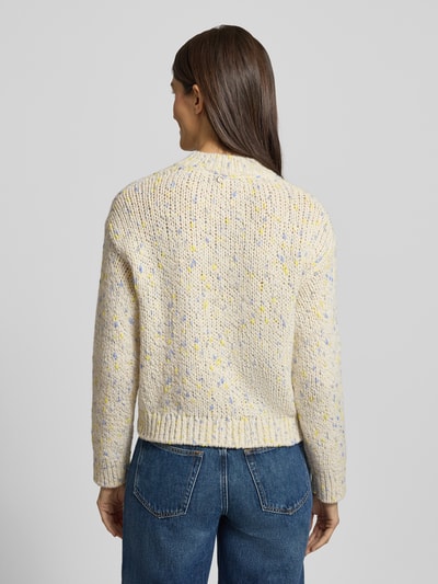 Frauenmodel trägt Strickjacke mit Knopfleiste von Rich & Royal in hellem Schurwoll-Mix mit bunten Punkten, lockerer Schnitt, Ganzkörperansicht Rückansicht